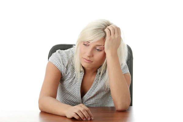 Mujer joven estresada sentada detrás de un escritorio —  Fotos de Stock
