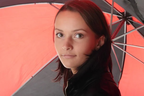 Женщина в черном под красным и черным зонтиком — стоковое фото