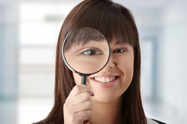 Business woman looking into a magniying glass — Stock Photo, Image