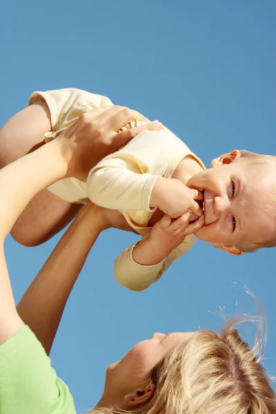 Madre con el bebé bajo el cielo azul —  Fotos de Stock