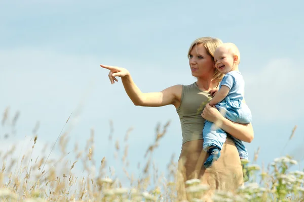 Mujer con bebé sobre sus hombros en un país —  Fotos de Stock