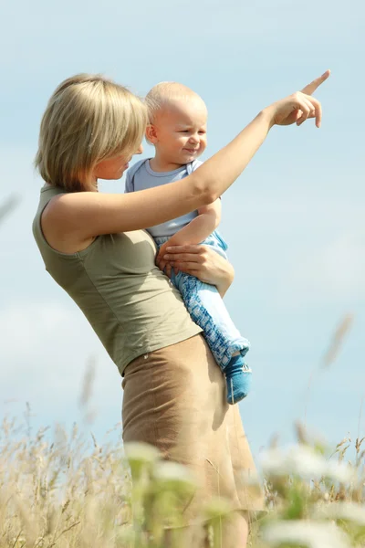 Mulher com bebê em seus ombros em um país — Fotografia de Stock