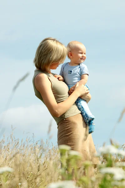 Frau mit Baby auf den Schultern in einem Land — Stockfoto