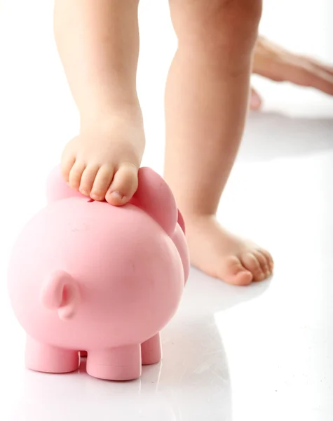 Nogi dziecka na piggy bank — Zdjęcie stockowe