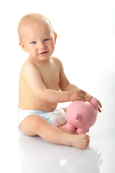 Tineri băiețel joc cu roz porc bancă — Fotografie, imagine de stoc