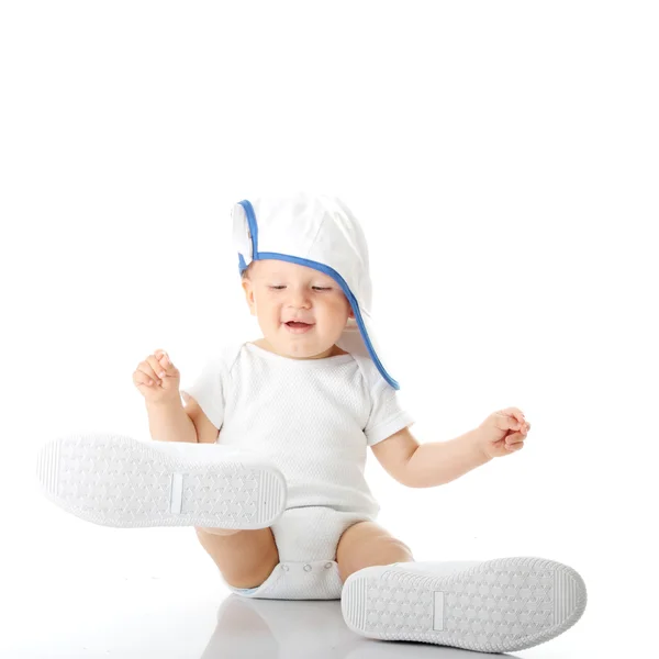 Bebê experimentando sapatos e boné de basebal — Fotografia de Stock