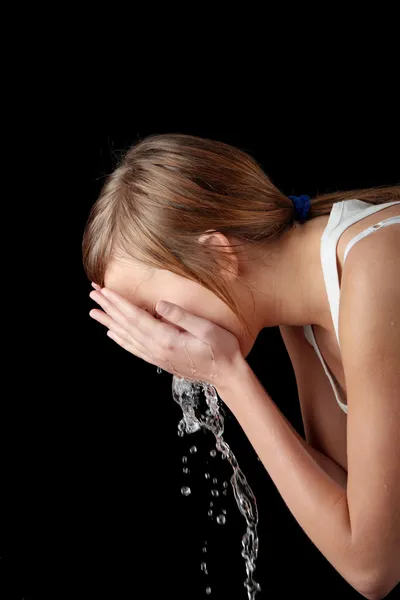 Дівчина-підліток миє обличчя водою — стокове фото