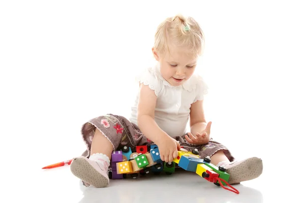 Kleine babymeisje met een stuk speelgoed — Stockfoto