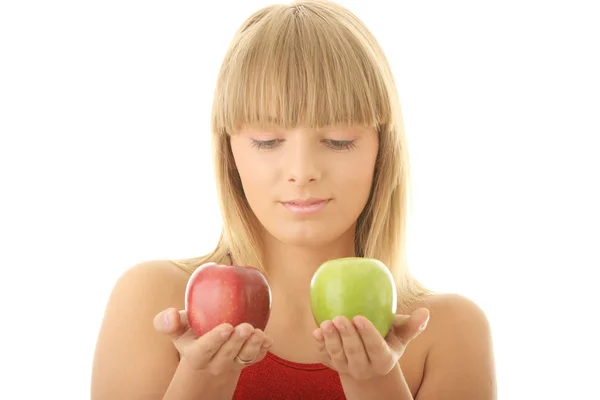 Молодая блондинка с красными и зелеными яблоками — стоковое фото
