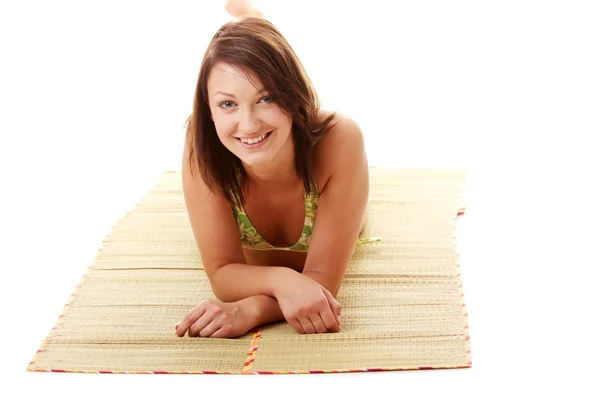 Женщина в купальнике на бамбуковом коврике — стоковое фото