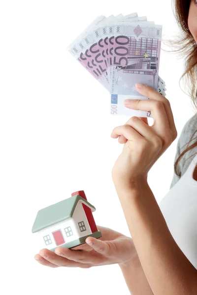 Mujer joven sosteniendo billetes de euros y modelo de casa —  Fotos de Stock
