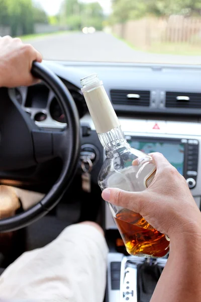 Dronken bestuurder op een landelijke weg met alcohol in hand — Stockfoto