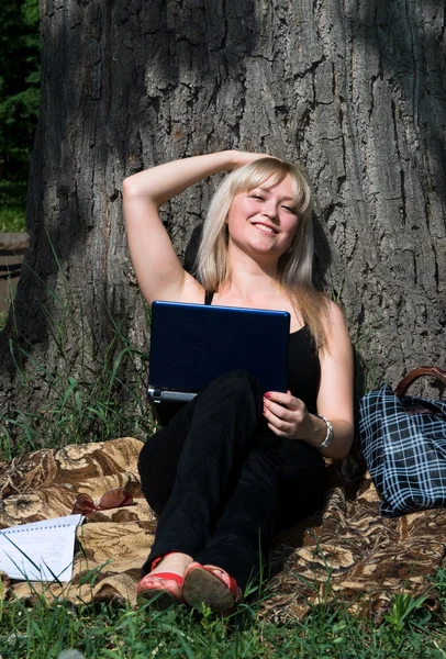 Den unge, snille jenta med laptopen i parken. – stockfoto
