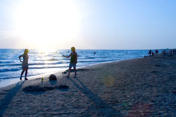 Hermosa puesta de sol en el mar con las siluetas de walki —  Fotos de Stock