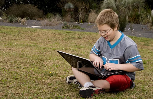 Glimlachende jongen met behulp van een computer — Stockfoto