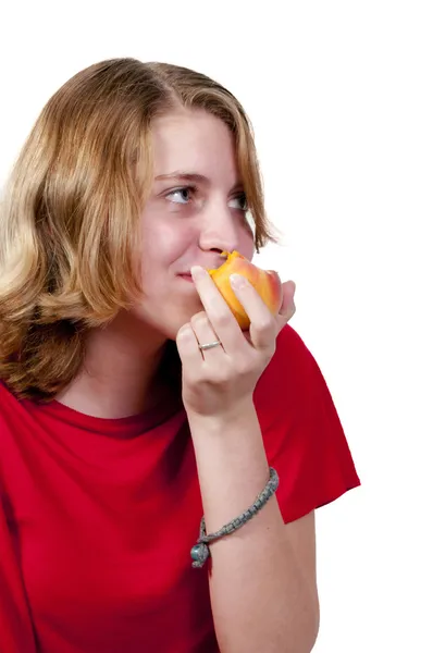 Tienermeisje eten een perzik — Stockfoto