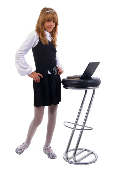 Schoolgirl en laptop op de stoel. — Stockfoto