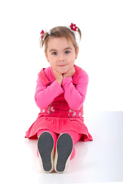 Istuva tyttö lapsi vaaleanpunainen mekko . — kuvapankkivalokuva