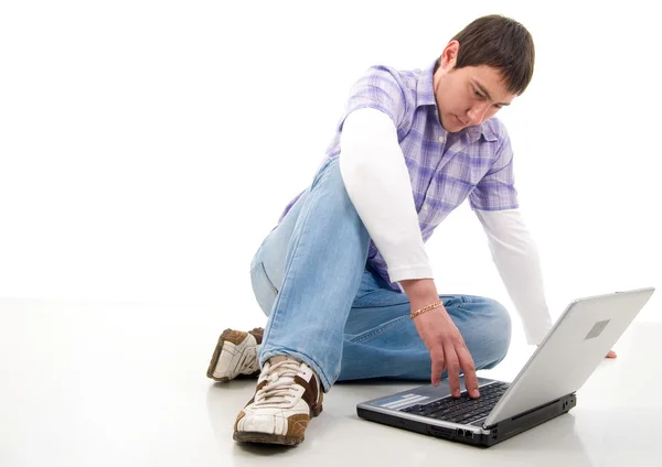 Сидящий молодой человек с ноутбуком . — стоковое фото