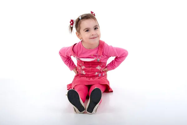 Sitzendes kleines Mädchen in rosa. — Stockfoto
