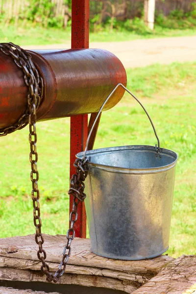 Empty pail, chain and well pulley — Stock Photo, Image