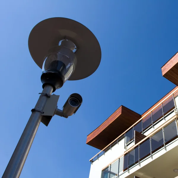 Neue Häuser und Überwachungskamera an der Lampe — Stockfoto