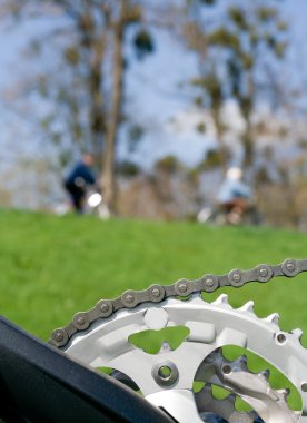 Bicycle chain over blurred cyclist clipart