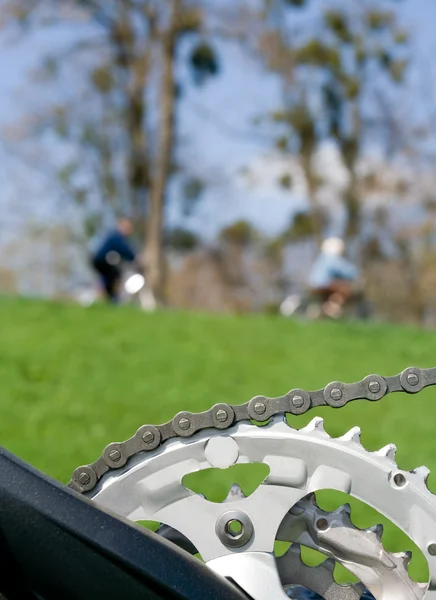 Велосипедная цепь над размытым велосипедистом — стоковое фото