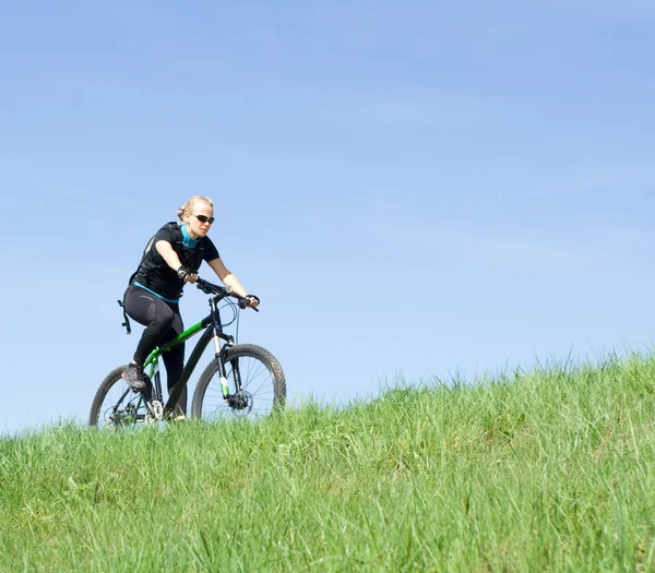 Genç kadın dağ bisikleti üzerinde sürme — Stok fotoğraf