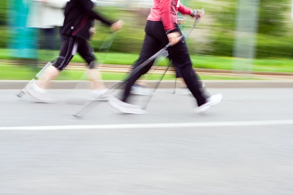 Kobiety na nordic walkingu wyścigu, niewyraźne — Zdjęcie stockowe