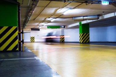 Moving blurred car in parking garage clipart