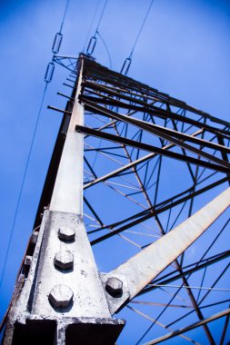 Silhouette of electricity pylon over blue stormy sky clipart