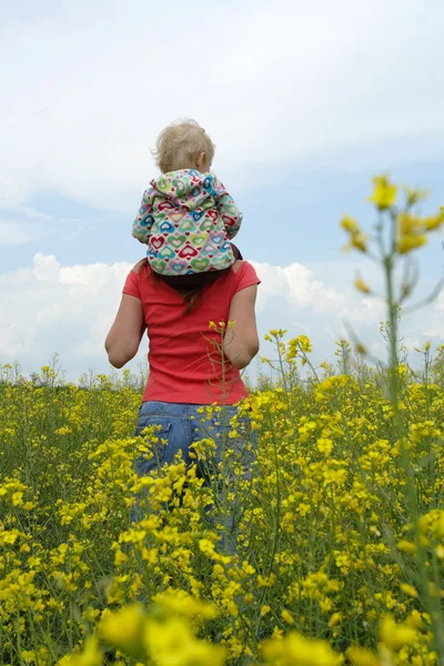 Mother with child on a yellow field — Stock Photo, Image