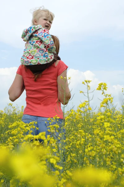Мать с ребенком на желтом поле — стоковое фото