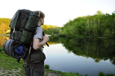 Teenage hiker standing by Sunrise Lake clipart