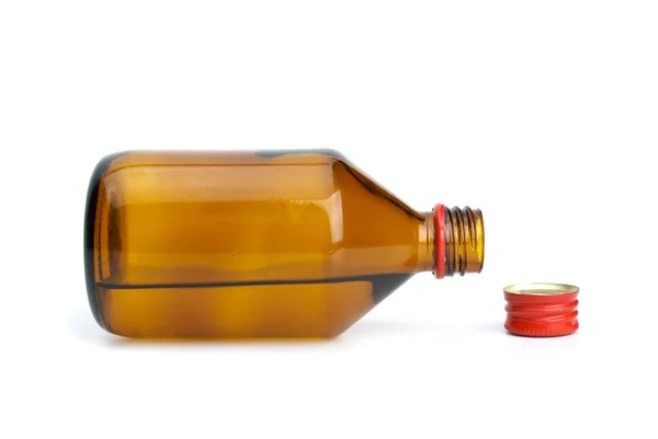 Бутылка с жидкостью и колпачок рядом — стоковое фото