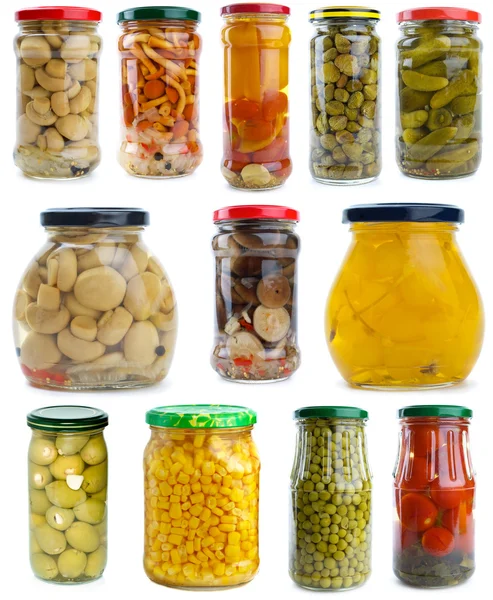 Set of different berries, mushrooms and vegetables conserved in glass jars — Stock Photo, Image