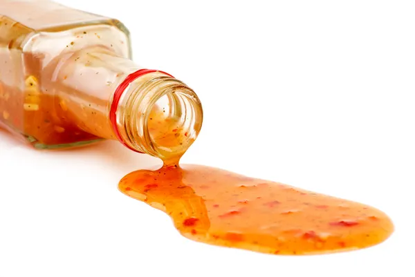 Piquant red sauce leaking from the bottle — Stock Photo, Image
