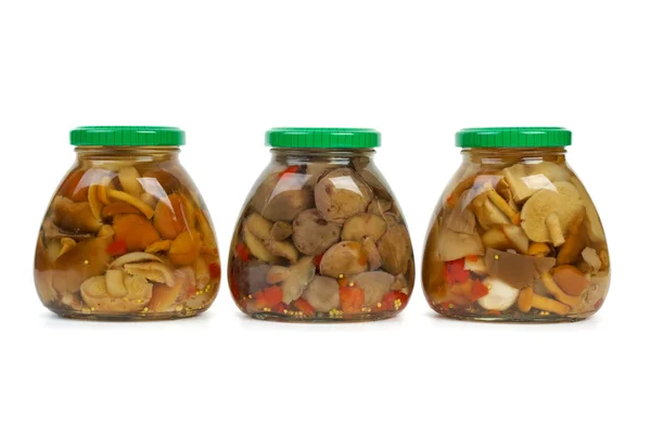 Three glass jars with marinated mushrooms — Stock Photo, Image