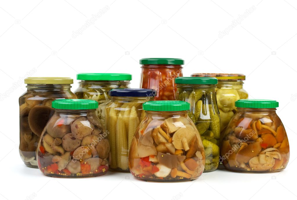 Glass jars with marinated vegetables and mushrooms