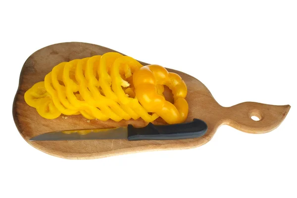 Tábua de corte com pimentão amarelo fatiado e faca pequena — Fotografia de Stock