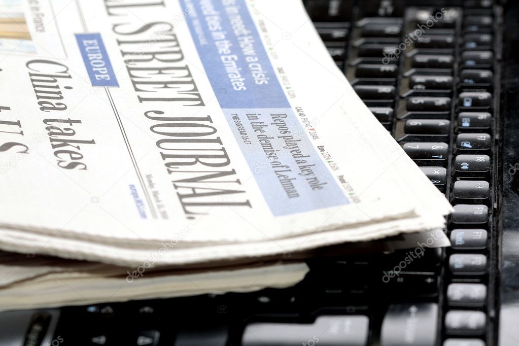 Newspapers on laptop keyboard