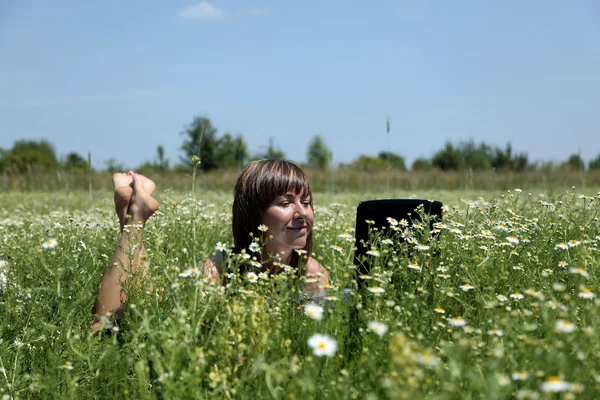 Trabalhando com laptop no prado — Fotografia de Stock