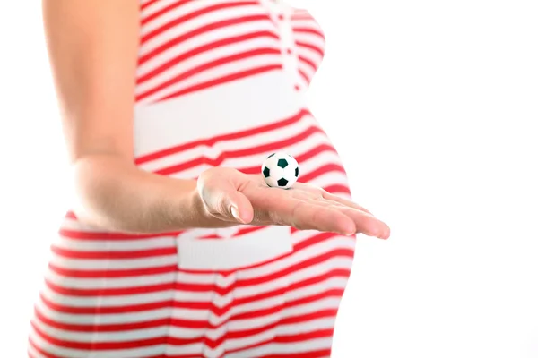 Ventre de femme enceinte avec ballon de football à la main — Photo