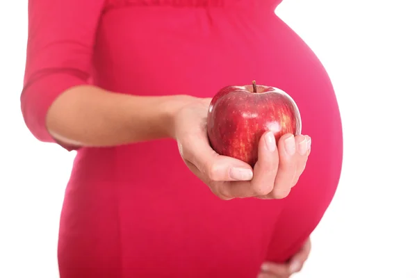 Eine schwangere Frau hält einen Apfel. — Stockfoto