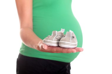 Little shoes on pregnant woman Hand. It will be a son! clipart