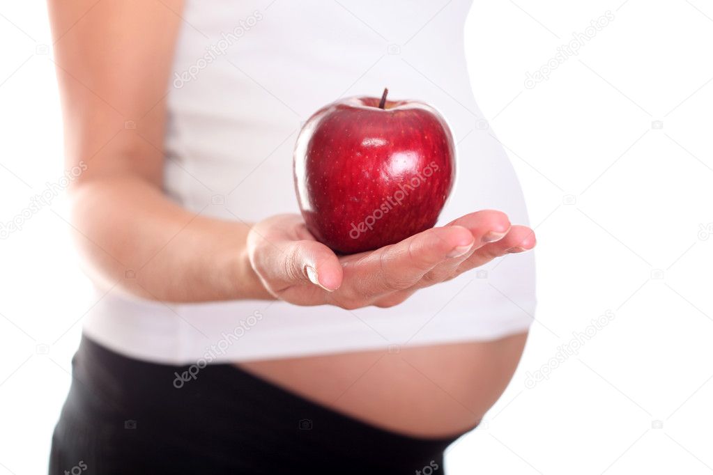 A pregnant woman holding an apple