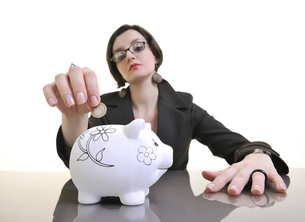 Mulher colocando moedas no banco porquinho — Fotografia de Stock