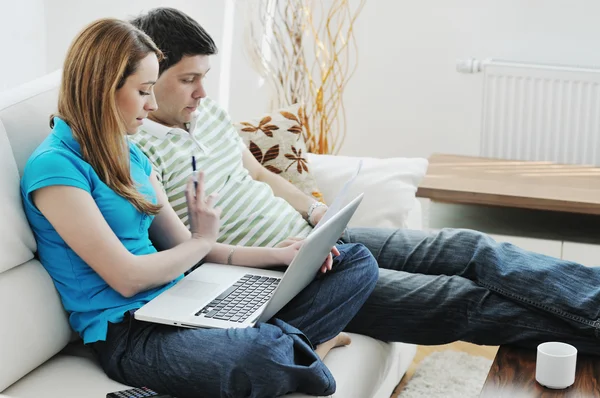 Mladý pár, pracovat na notebooku doma — Stock fotografie