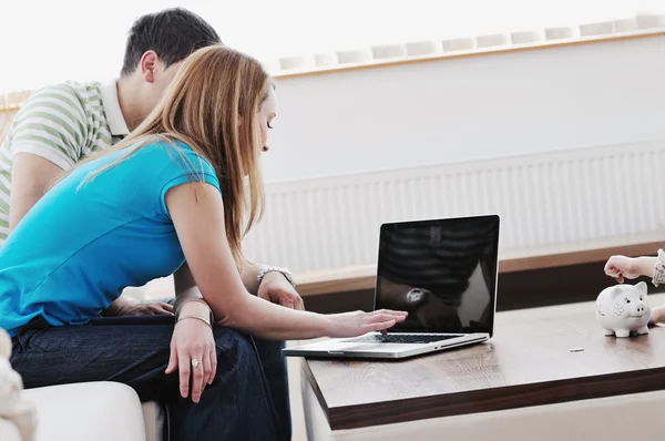 Молодая пара, работающая на ноутбуке дома — стоковое фото